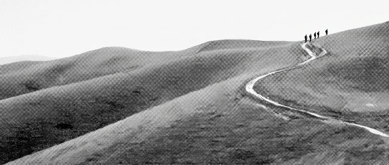 A hill road walked by a distant group of people