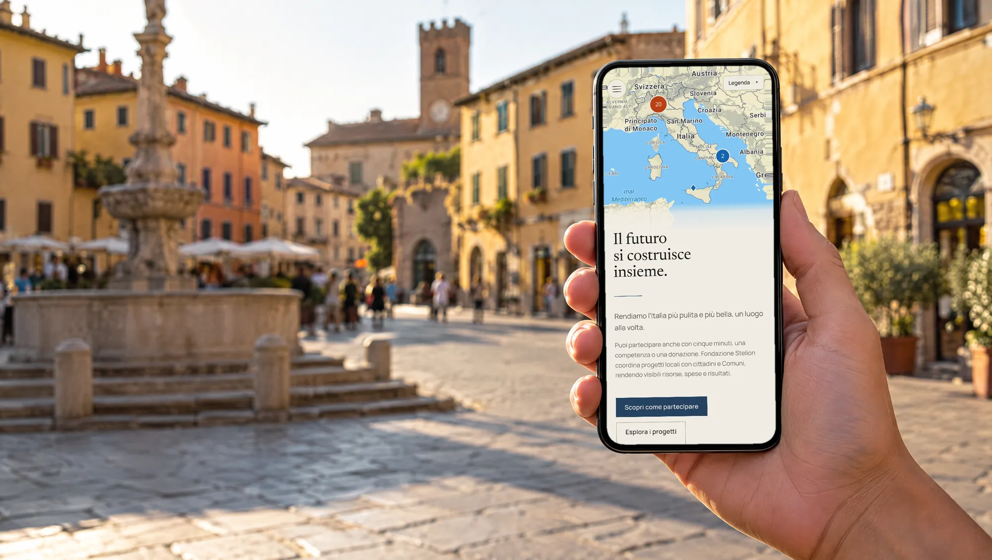 The Fondazione Stelion website on a phone held up in a historic square