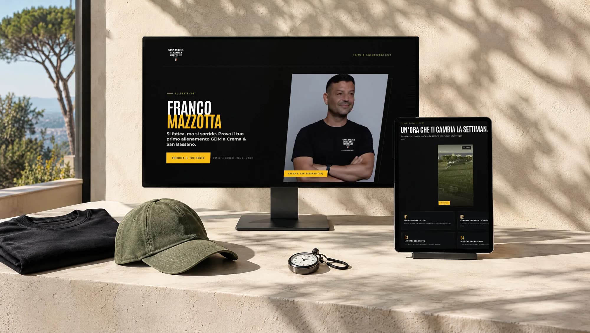 A GDM Italia instructor landing page on a monitor and a tablet, on a light sunlit surface